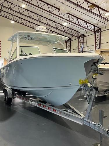 Sailfish 276 DC 2025 Sailfish 276 DC boat on Venture trailer in indoor showroom.