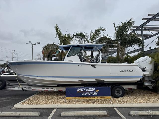 Blackfin 332cc 2025 Blackfin 332cc boat displayed at dealership with palm trees in background.