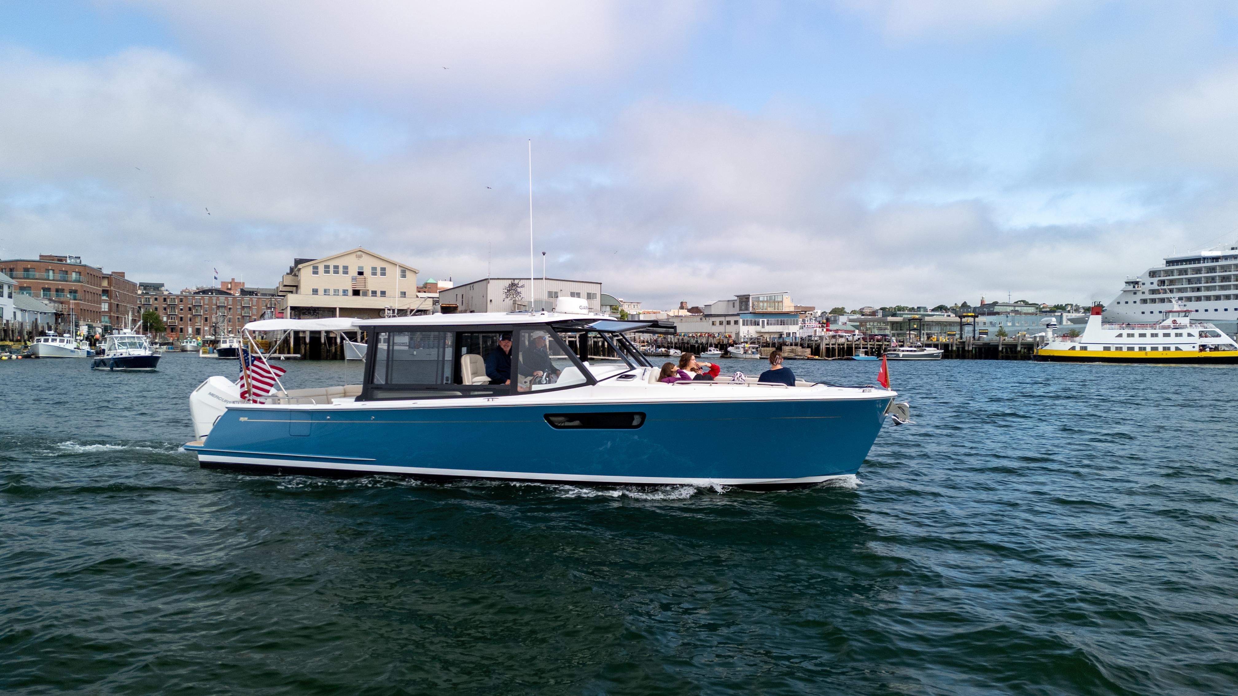 MJM 3 2025 MJM 3 boat cruising in a harbor with cityscape background.