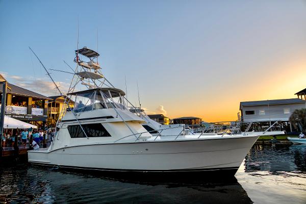 Hatteras Convertible 1989 Hatteras Convertible yacht docked at sunset, with people nearby.