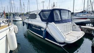 Aquador 26 HT Aquador 26 HT 1999 boat docked in a marina, surrounded by other vessels.