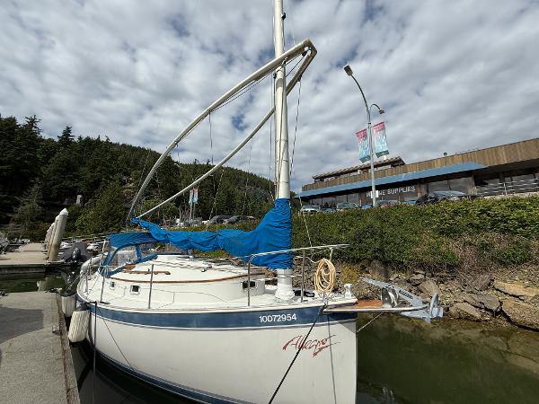 Hinterhoeller Nonsuch Ultra 1986 Hinterhoeller Nonsuch Ultra sailboat docked at marina under cloudy sky.