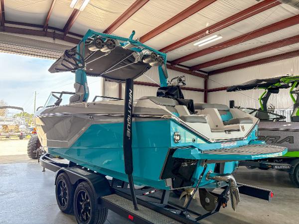 Nautique G21 2022 Nautique G21 boat in a garage, vibrant blue color, on a trailer.