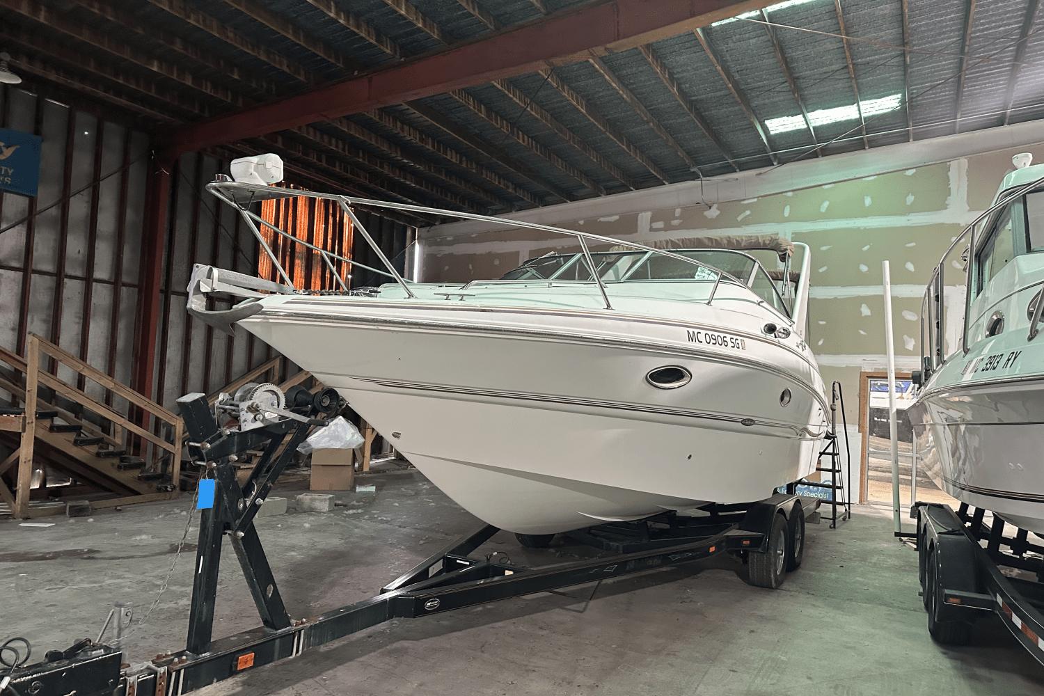 Larson Cabrio 270 Mid Cabin 2001 Larson Cabrio 270 boat on trailer in indoor storage facility.