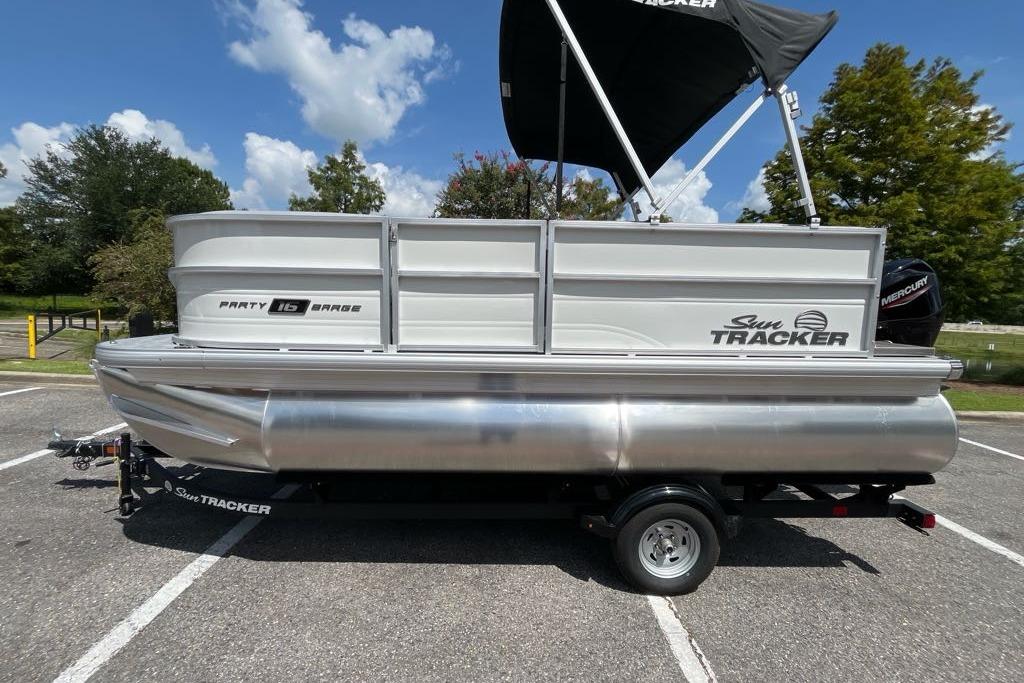 Sun Tracker Party Barge 16 DLX 2026 Sun Tracker Party Barge 16 DLX pontoon boat parked outdoors.