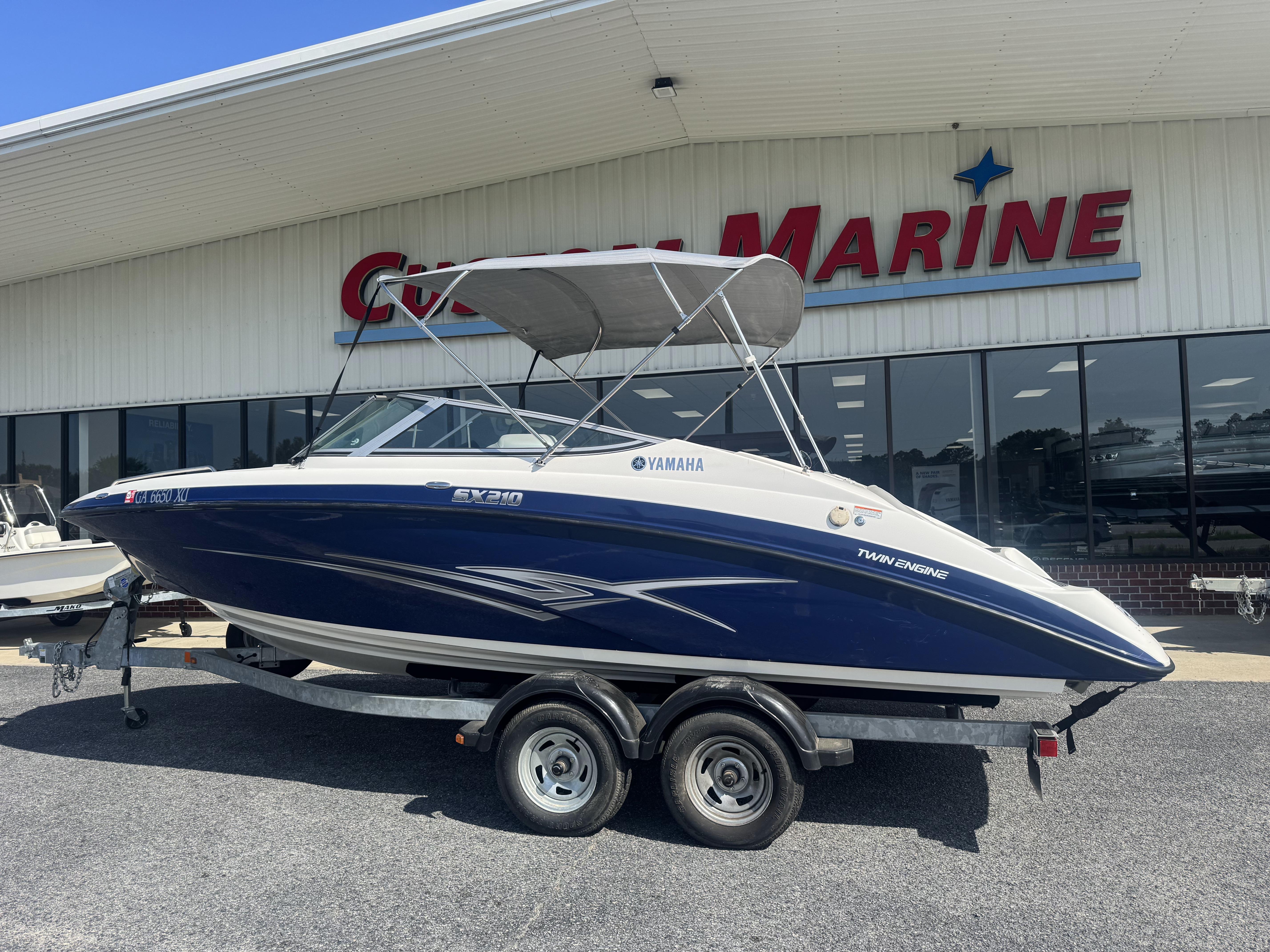 Yamaha Boats SX210 2012 Yamaha SX210 boat on trailer outside marine dealership.
