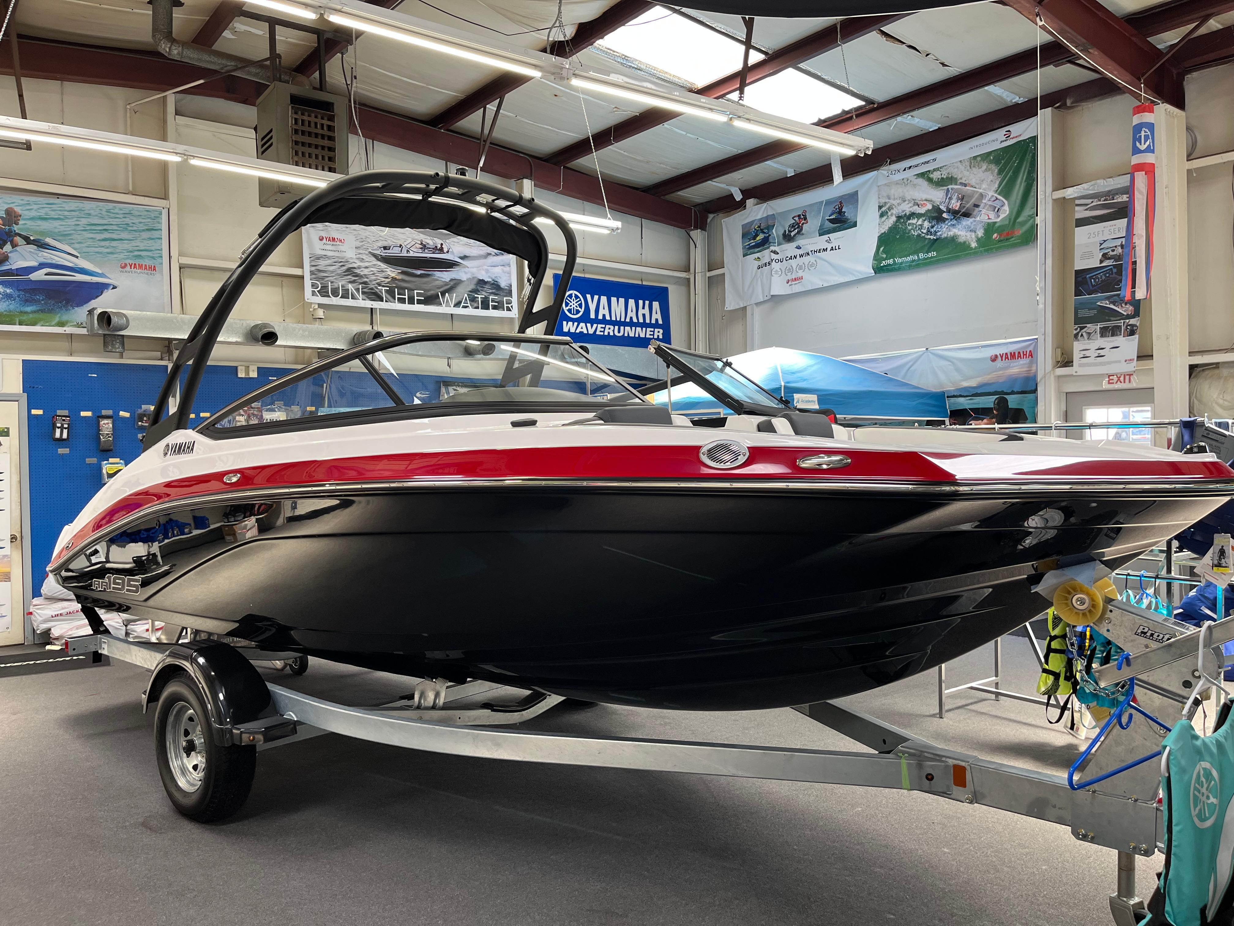 Yamaha Boats AR195 2025 Yamaha AR195 boat displayed in showroom, featuring sleek design and vibrant colors.