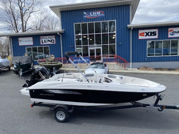 Bayliner Element E18 2025 Bayliner Element E18 boat on trailer outside dealership.