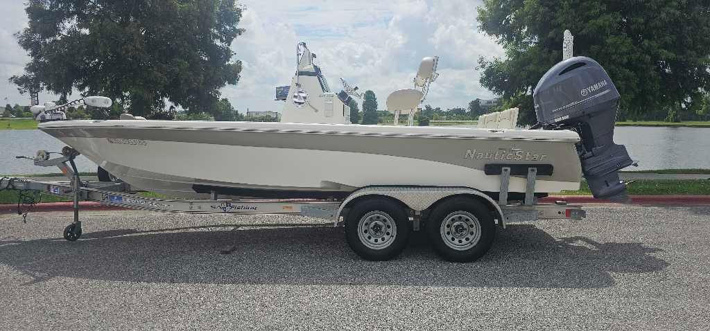NauticStar 214 XTS 2016 NauticStar 214 XTS boat on trailer, parked near a lake.