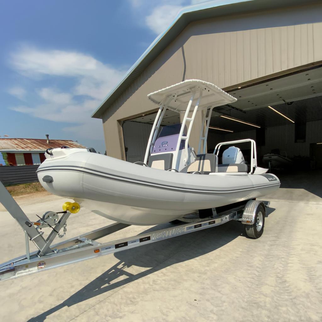 Gala V500 2026 Gala V500 boat on trailer outside a garage, ready for transport.