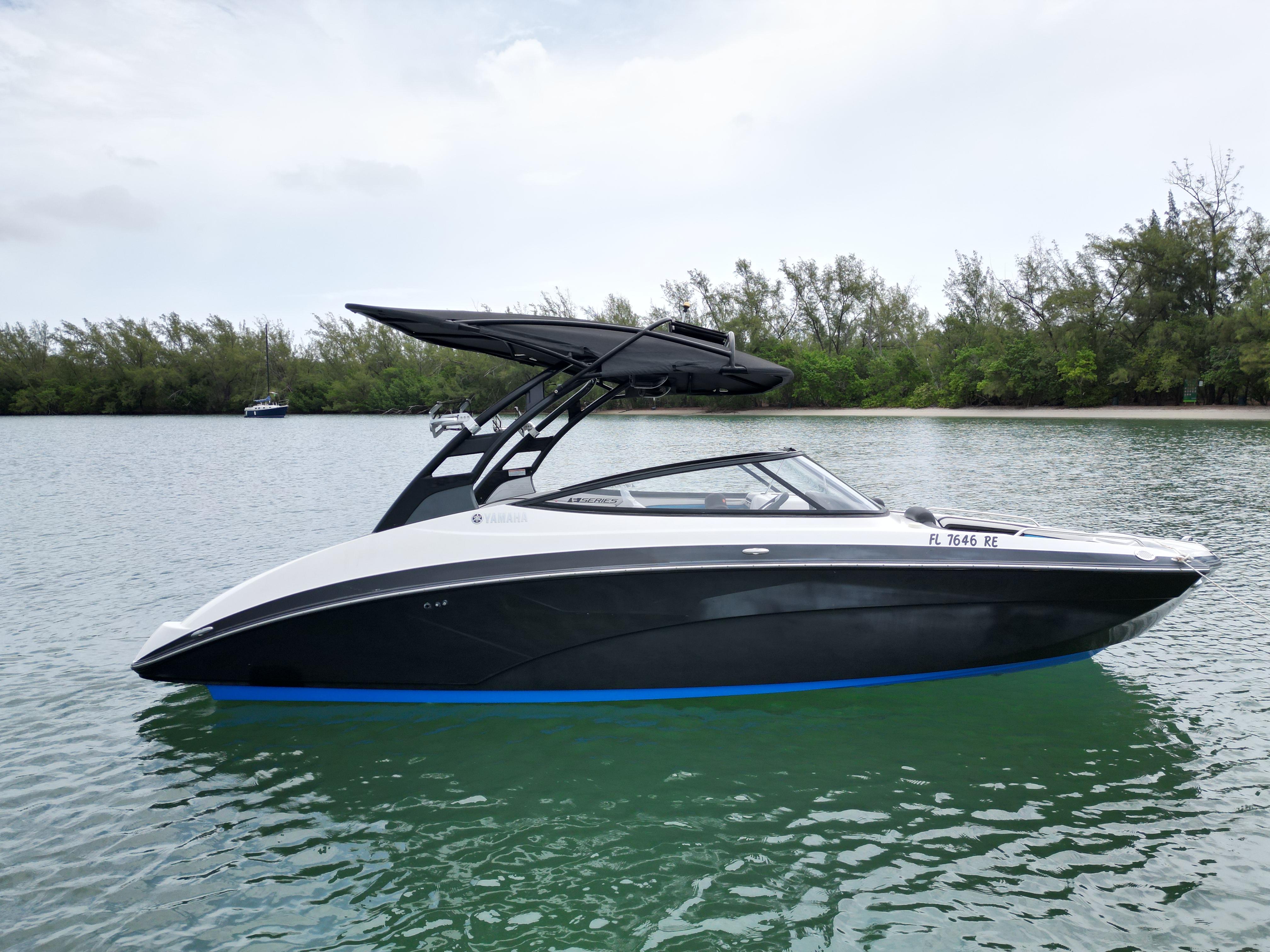 Yamaha Boats 242X E-Series 2016 Yamaha Boats 242X E-Series on calm water with lush green shoreline.
