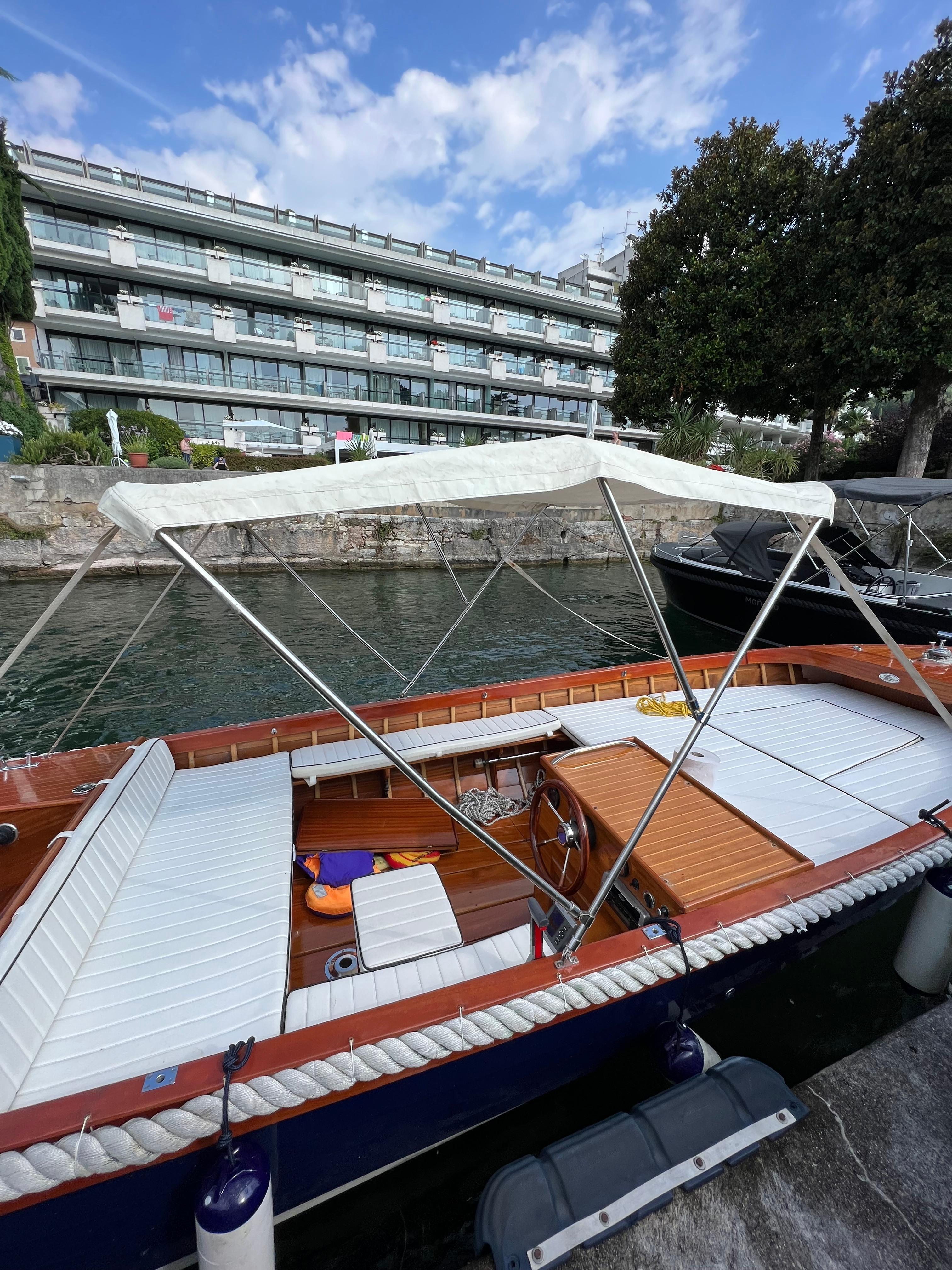 Custom ISY600 Custom ISY600 boat docked by modern building, featuring white canopy and seating, 2005 model.