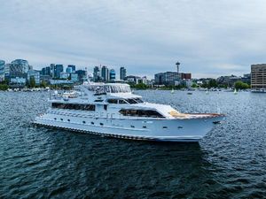 Broward 102 Luxurious 1991 Broward 102 yacht cruising on a scenic urban waterfront.