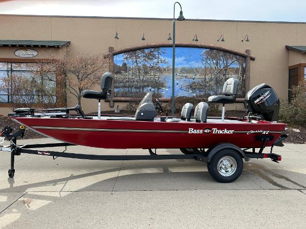Tracker Bass Tracker Classic XL 2025 Tracker Bass Tracker Classic XL boat, red, parked outdoors with scenic mural background.