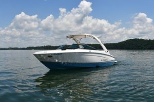 Regal LS4 2019 Regal LS4 boat on a calm lake under a partly cloudy sky.