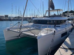 Lagoon 46 2024 Lagoon 46 catamaran docked in a marina under clear blue skies.
