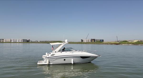 Regal 28 Express 2020 Regal 28 Express boat on calm water with buildings in the background.