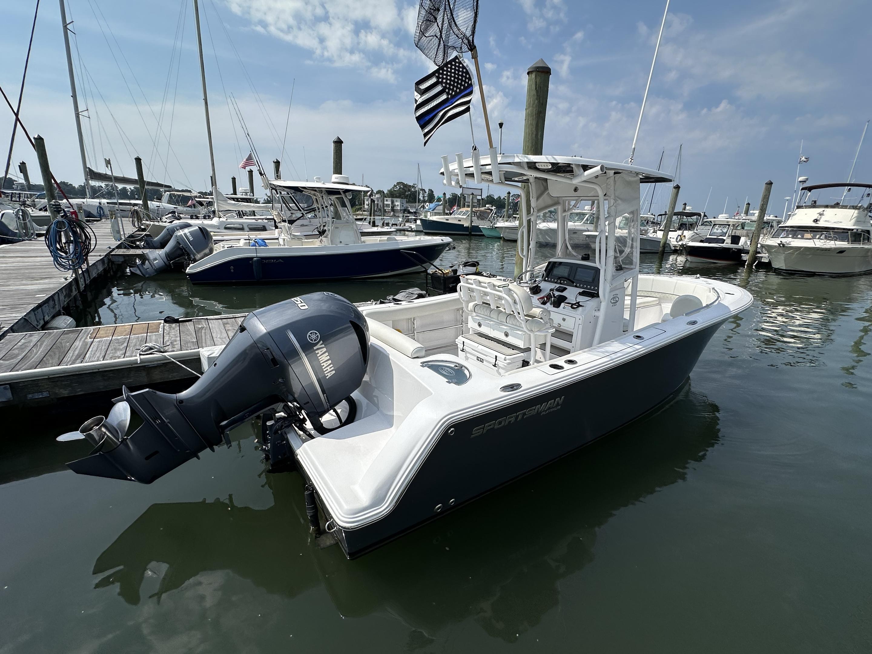 Sportsman Open 232 Center Console 2020 Sportsman 232 Open Platinum boat docked with Yamaha engine, marina background.