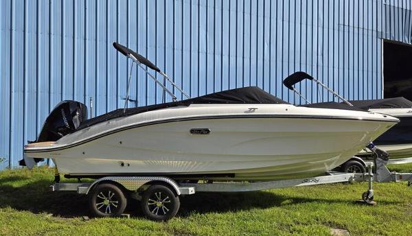 Sea Ray SPX 210 Outboard 2025 Sea Ray SPX 210 OB boat on trailer near blue building.