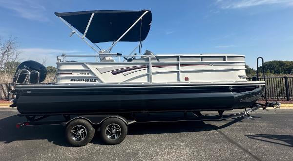Ranger Reata 220C 2023 Ranger Reata 220C pontoon boat on trailer with canopy, parked outdoors.