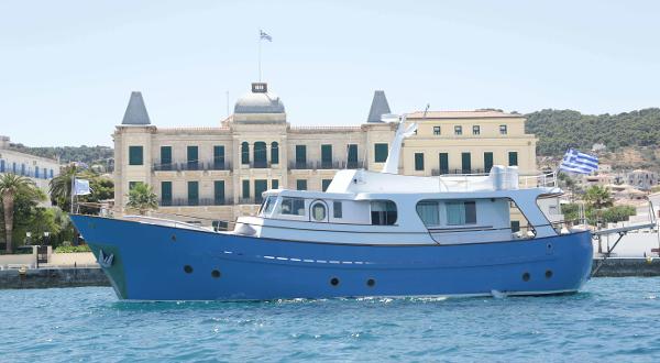 Navalia Classic Cabin Cruiser 57 Navalia Classic Cabin Cruiser 57, 1975, docked near historic building, clear sky.