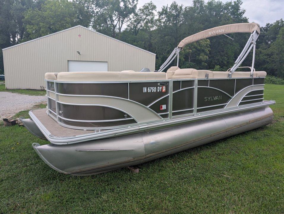 Sylvan Mirage Cruise 8520 CR 2017 Sylvan Mirage Cruise 8520 CR pontoon boat on grass near a beige building.