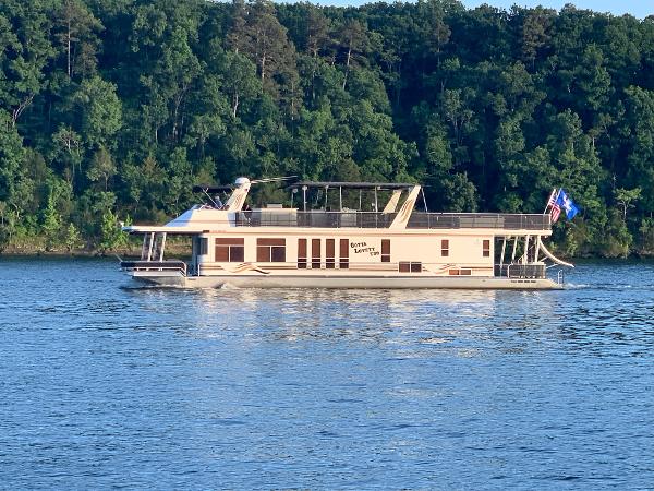 Sharpe 75' Houseboat 2003 Sharpe 75' Houseboat cruising on a lake with a forested background.