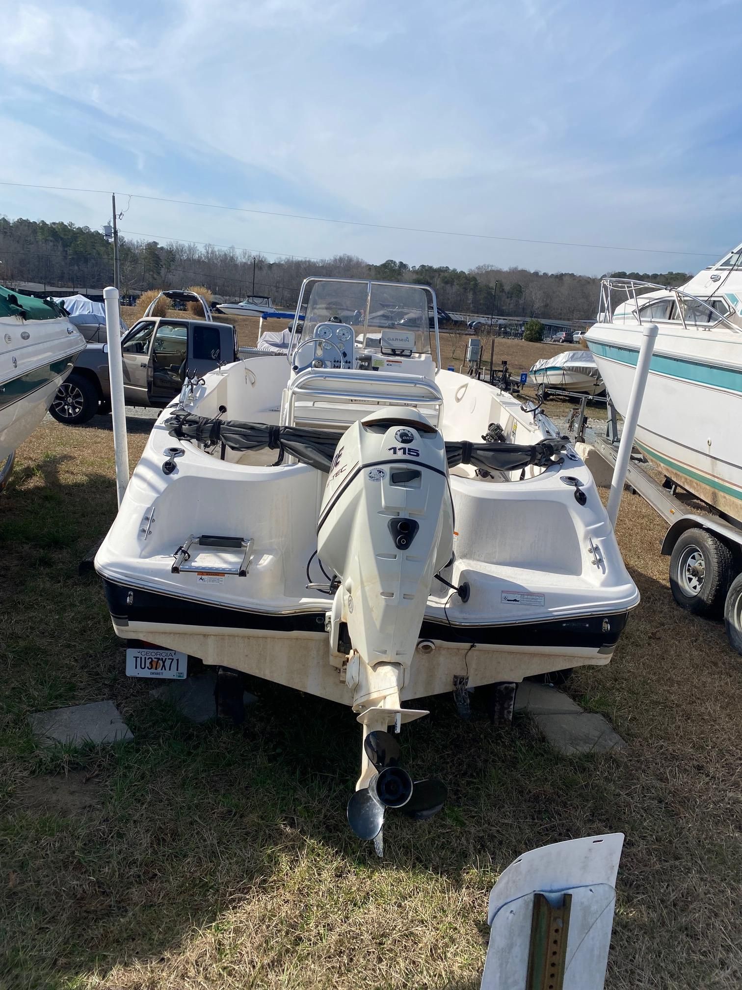 Wellcraft 180 Fisherman 2009 Wellcraft 180 Fisherman boat with outboard motor, parked on grass.