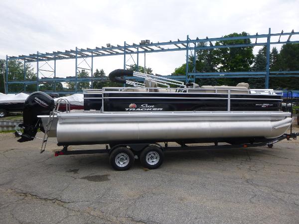 Sun Tracker Sportfish 24 XP3 2024 Sun Tracker Sportfish 24 XP3 pontoon boat on trailer, parked outdoors.