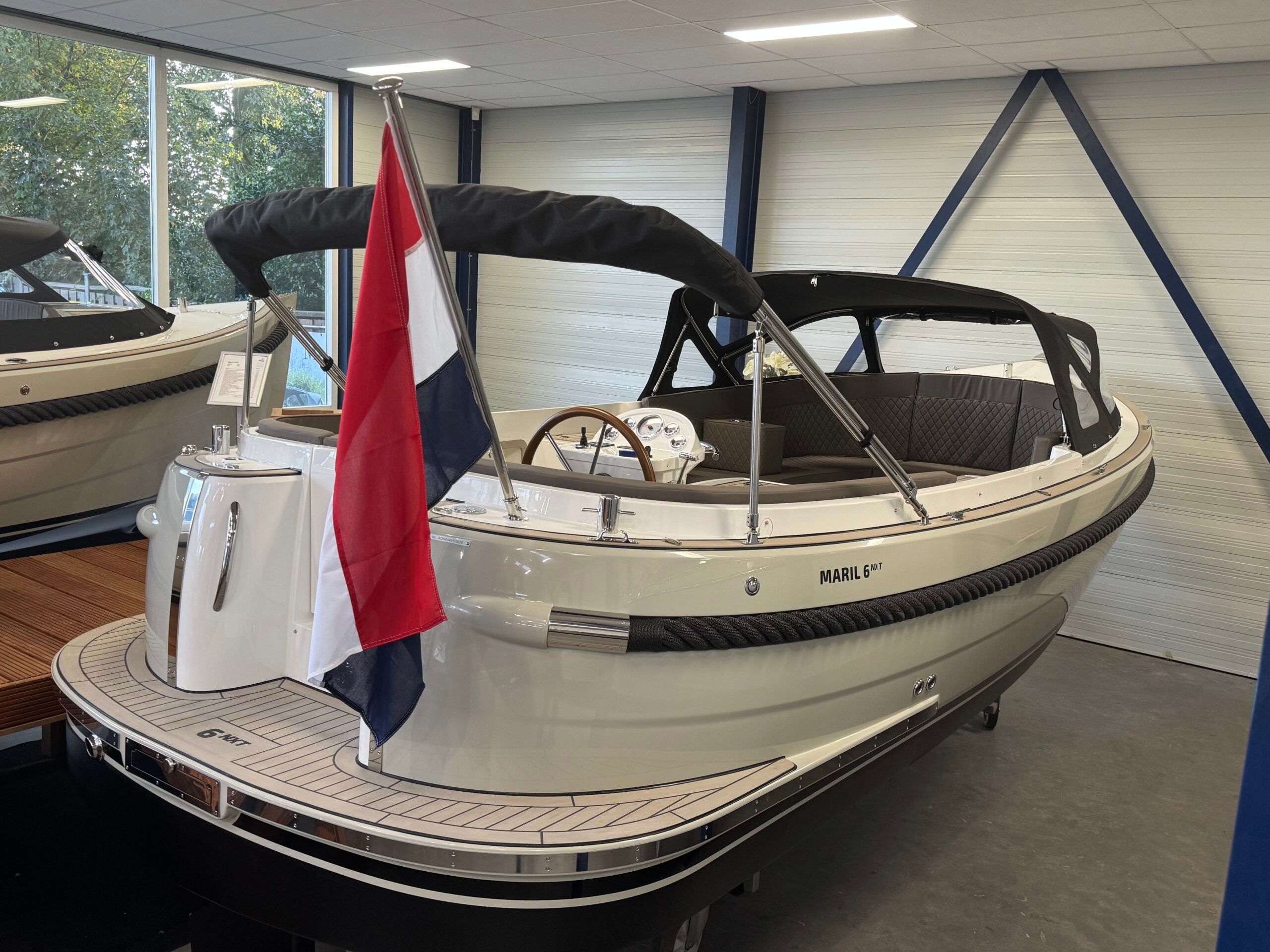Maril 6NXT (op voorraad) 2026 Maril 6NXT boat with Dutch flag displayed indoors.