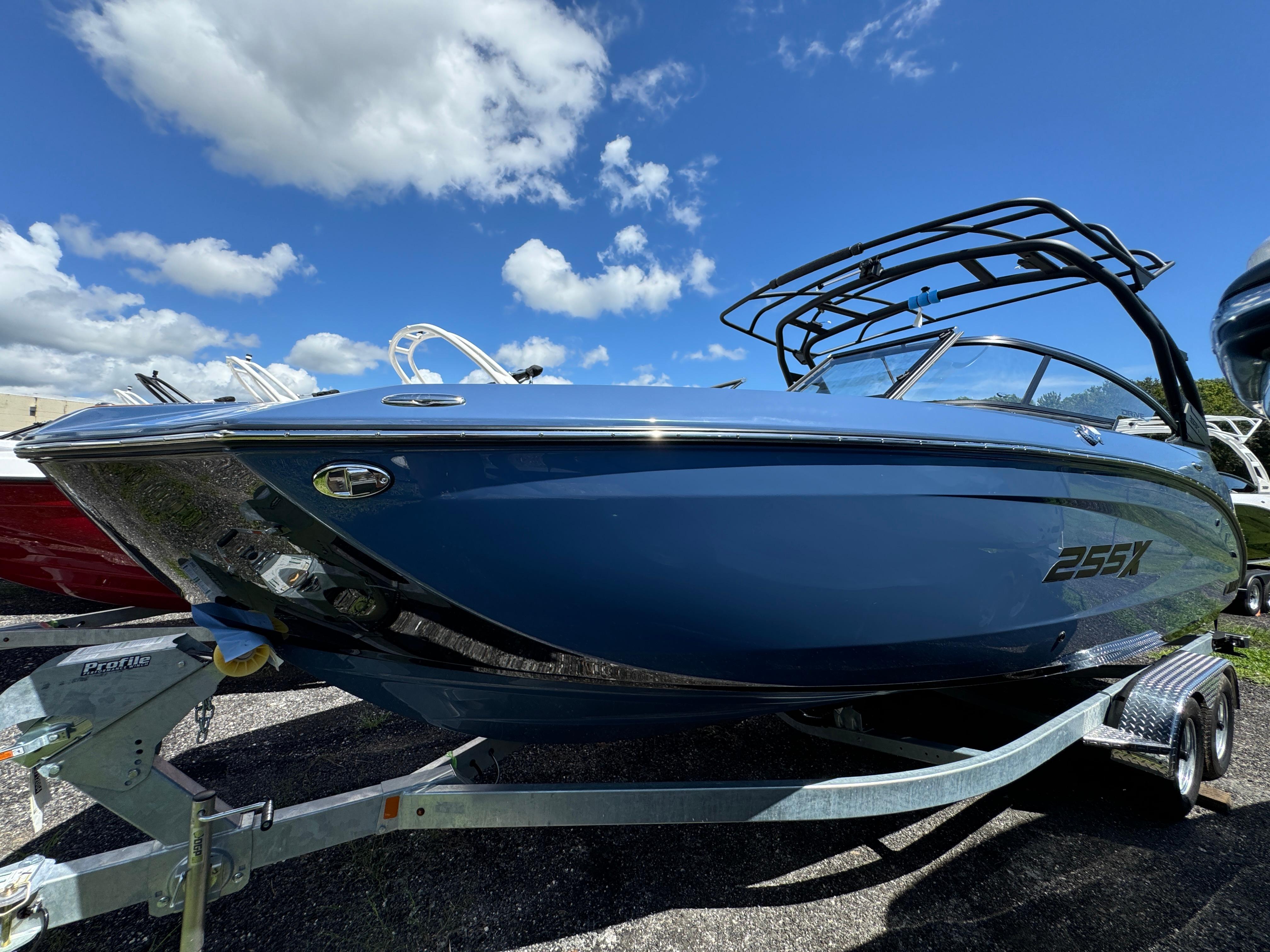 Yamaha Boats 255XD 2024 Yamaha Boats 255XD in blue, parked on a trailer under a clear sky.