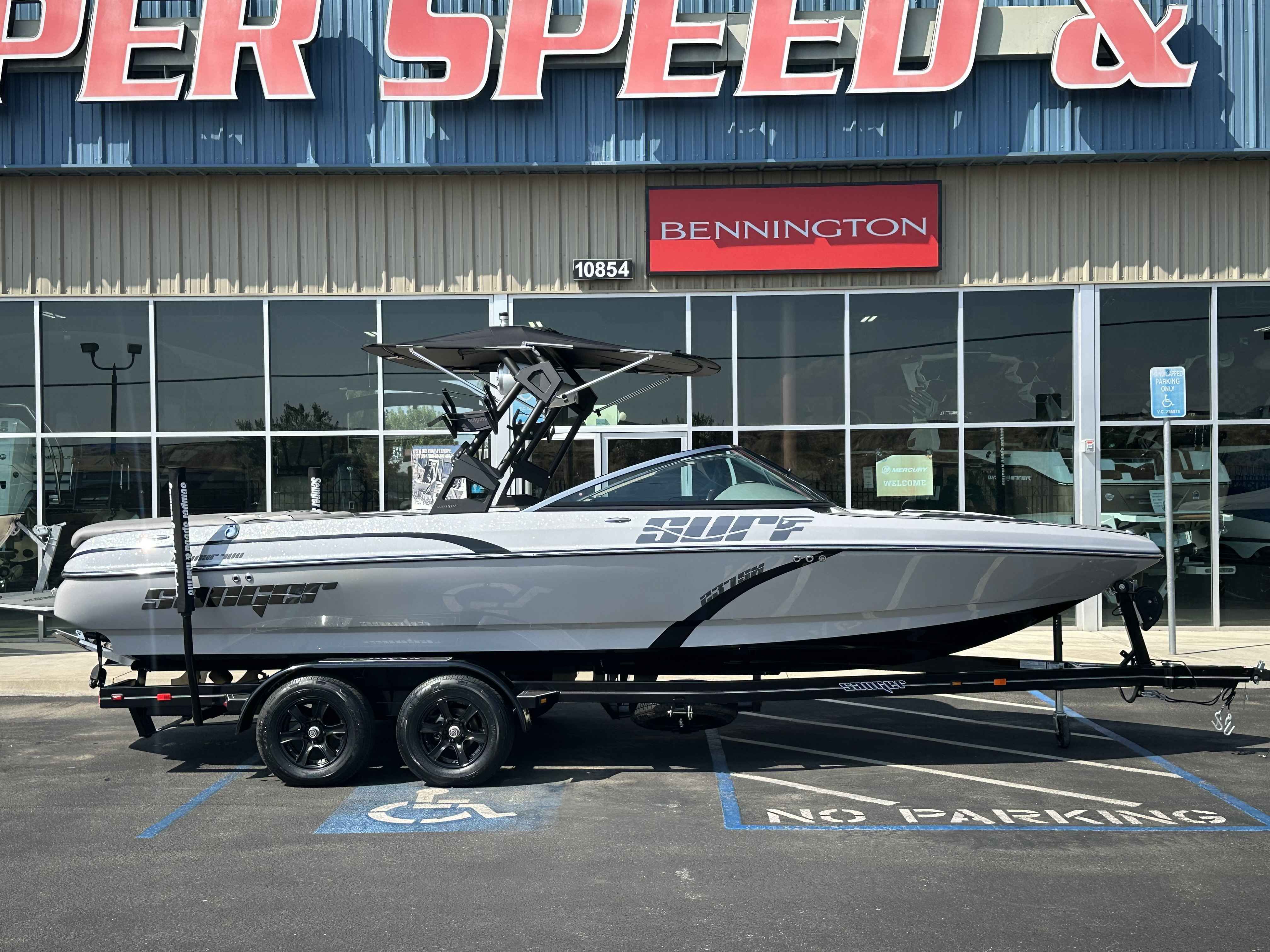 Sanger V237SX 2025 Sanger V237SX boat on trailer outside dealership, showcasing sleek design.
