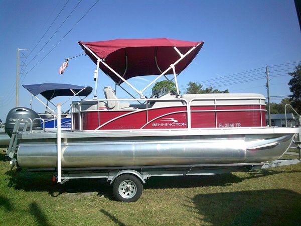 Bennington 20SLV 2023 Bennington 20SLV pontoon boat with red canopy on trailer, parked outdoors.