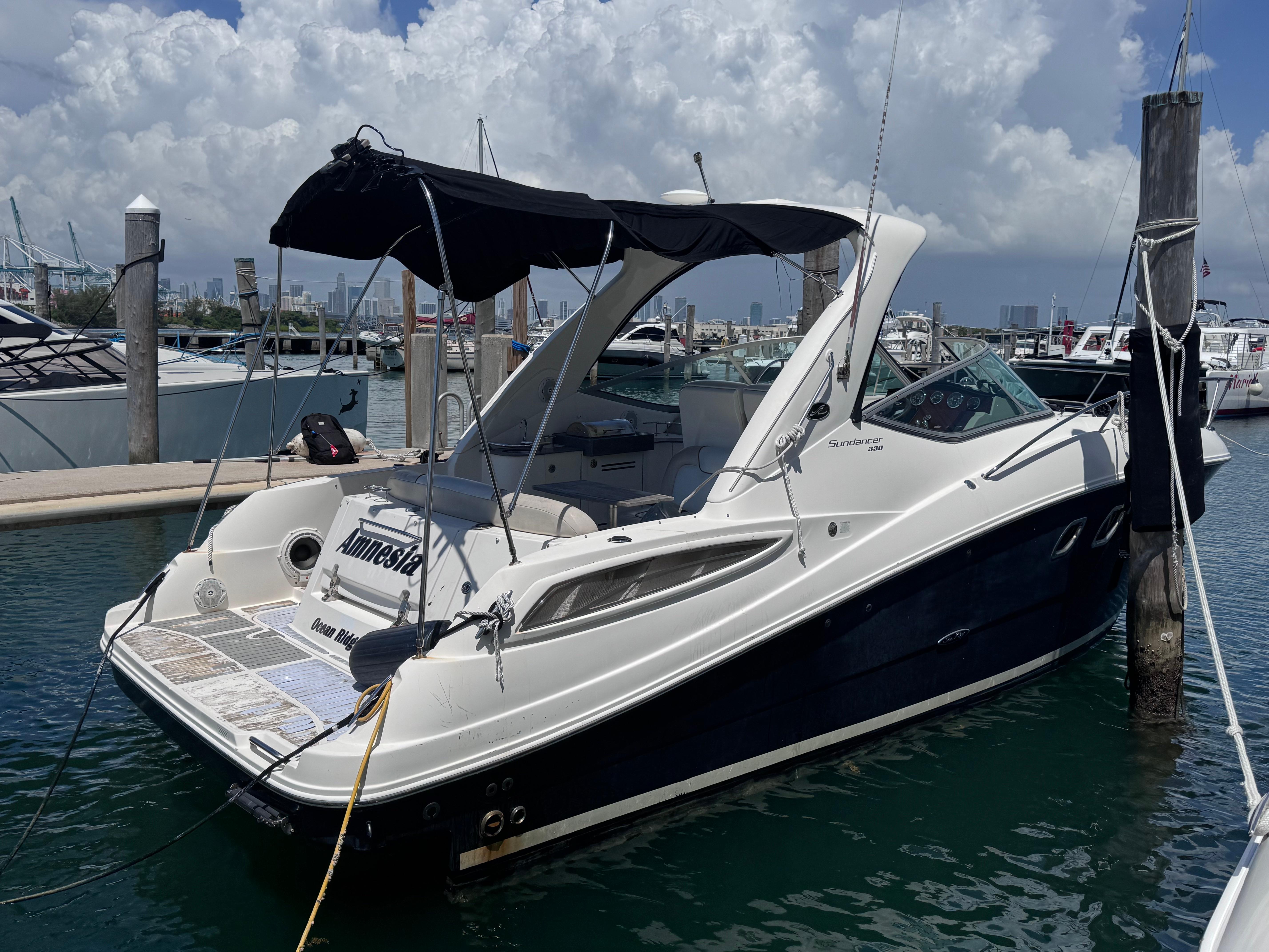 Sea Ray 330 Sundancer 2012 Sea Ray 330 Sundancer docked at marina under cloudy sky.