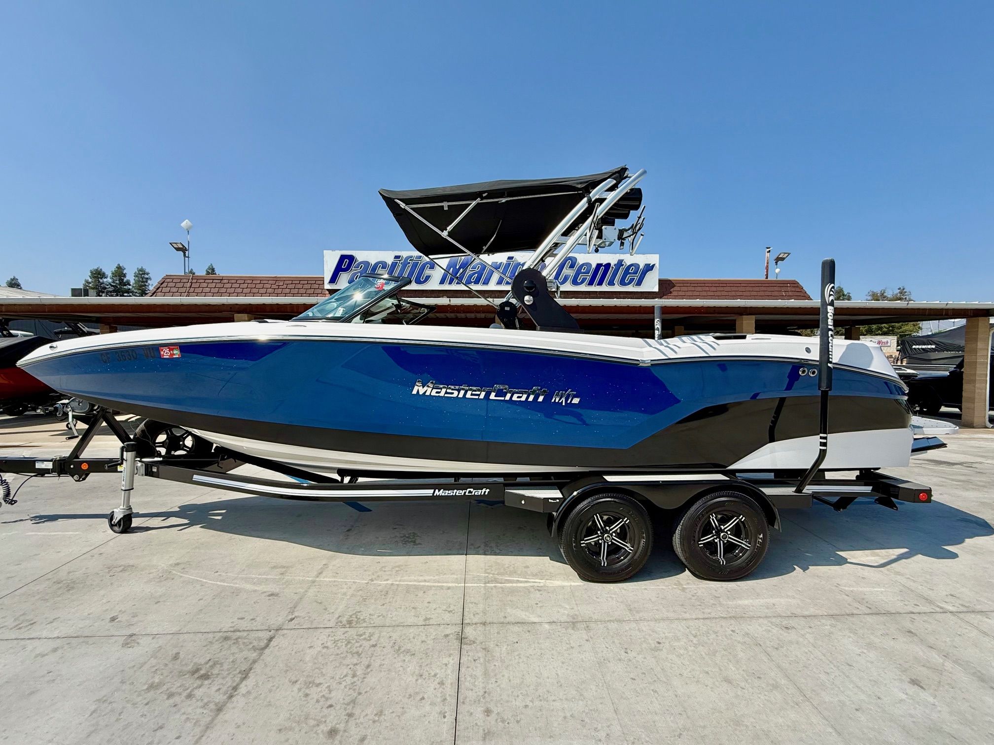 MasterCraft NXT24 2021 MasterCraft NXT24 boat in blue and white on a trailer at Pacific Marine Center.
