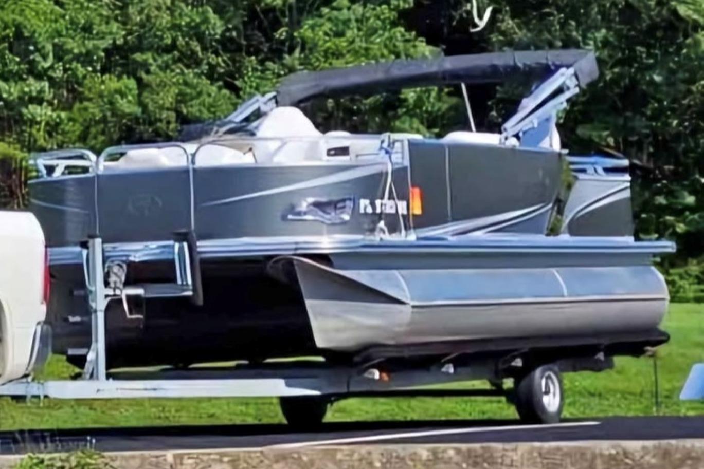 Avalon Catalina LSZ Fish - 20' 2016 Avalon Catalina LSZ Fish 20' pontoon boat on trailer, parked near lush greenery.