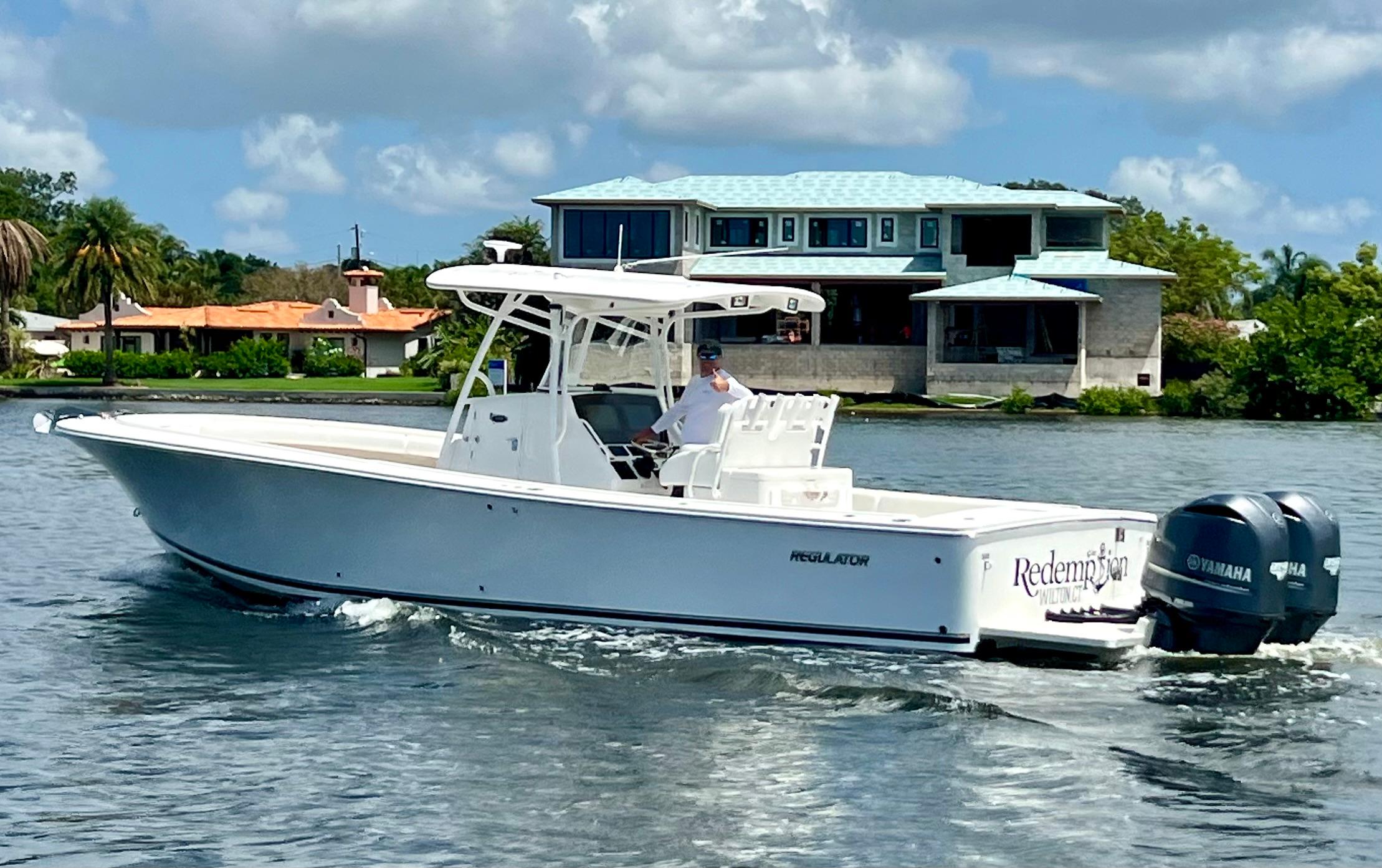 Regulator 34SS 2012 Regulator 34SS boat cruising on water near waterfront homes.