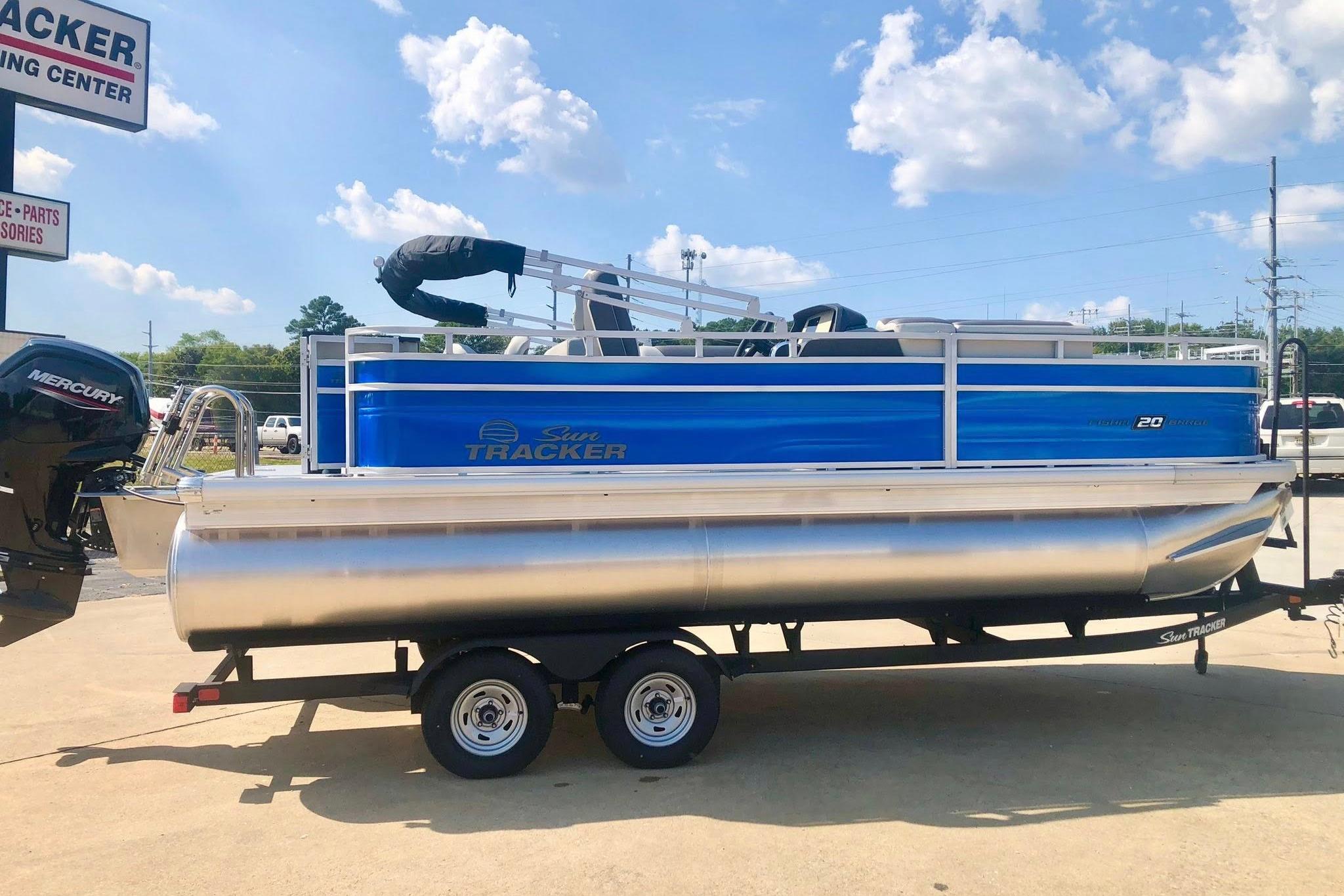 Sun Tracker Fishin' Barge 20 DLX 2026 Sun Tracker Fishin' Barge 20 DLX pontoon boat on trailer, sunny day.