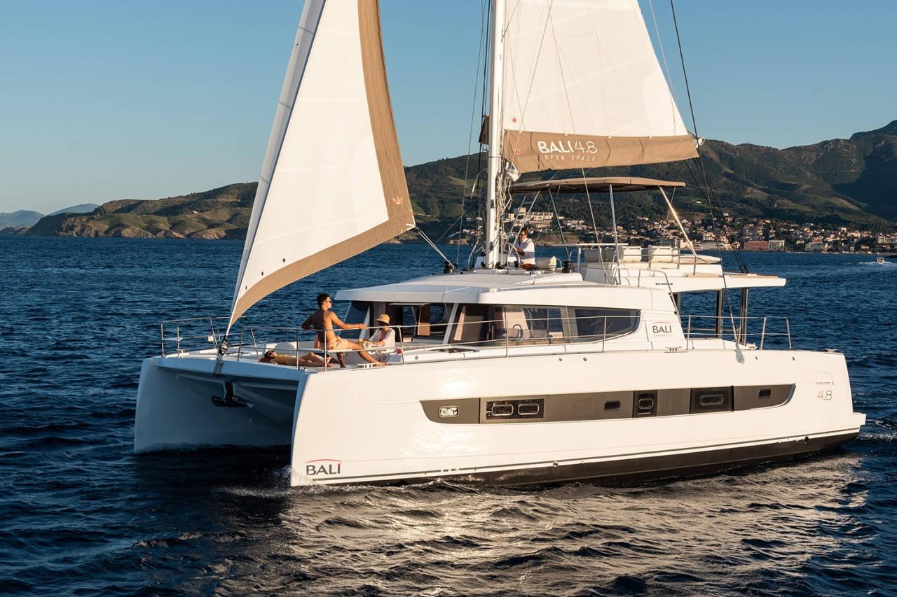 Bali Bali 4.8 Sailing catamaran Bali 4.8, 2020 model, cruising on open sea with scenic coastline backdrop.