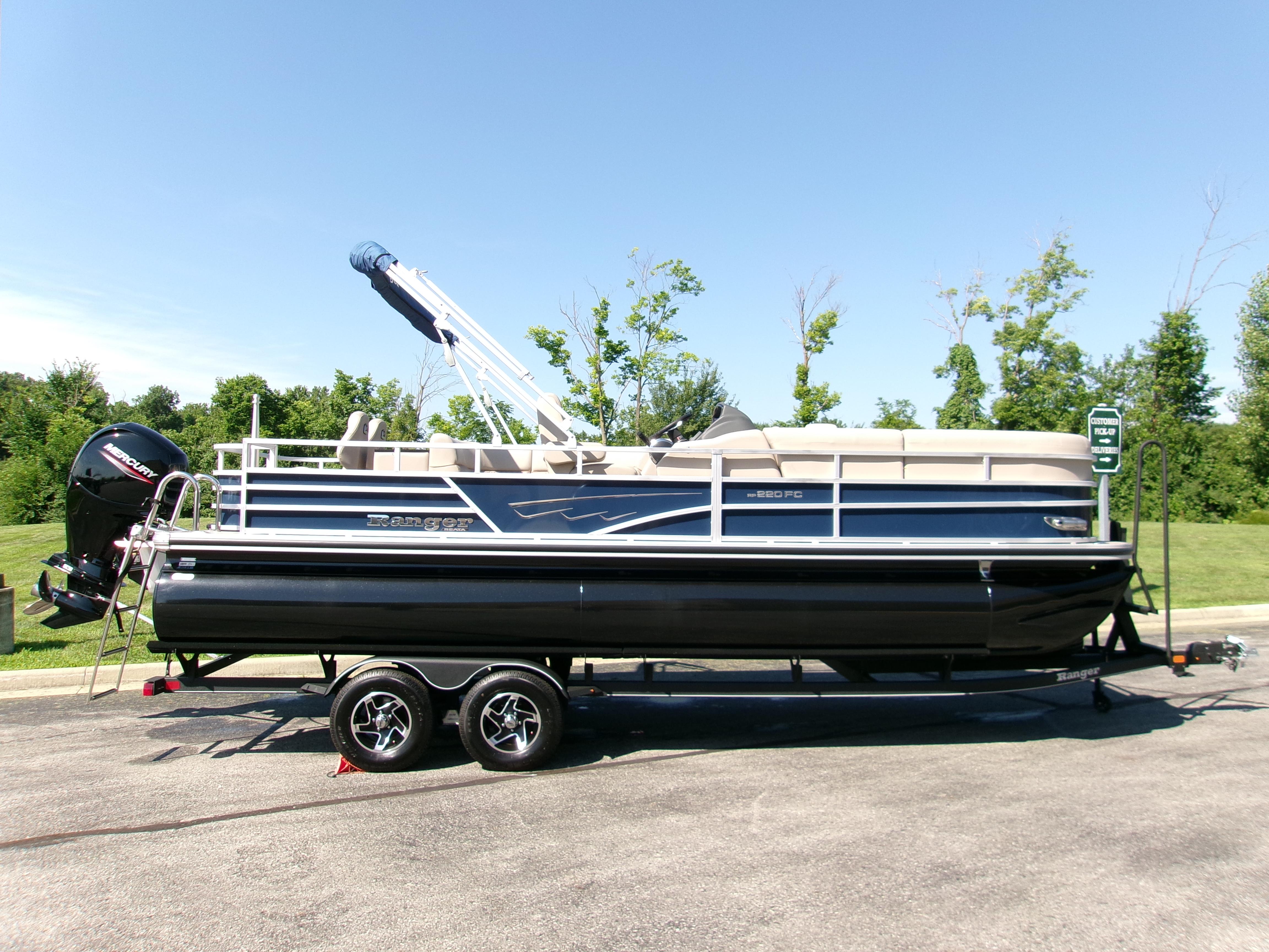 Ranger Reata 220FC 2024 Ranger Reata 220FC pontoon boat on trailer, parked outdoors on a sunny day.