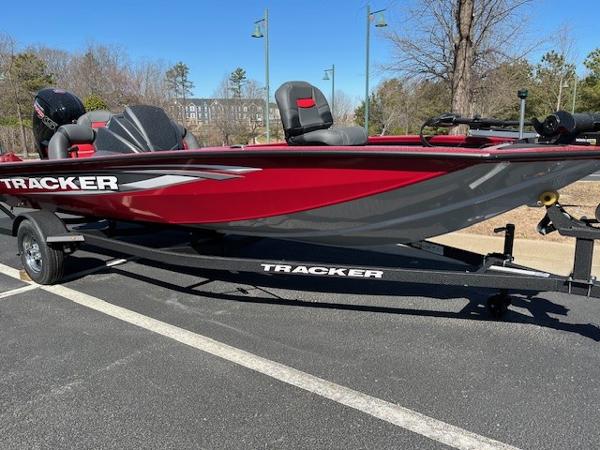 Tracker Pro Team 190 2025 Tracker Pro Team 190 boat, red and gray, on a trailer in a parking lot.