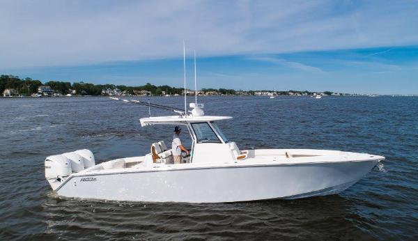 Jupiter 340LS 2024 Jupiter 340LS boat cruising on open water under a clear blue sky.