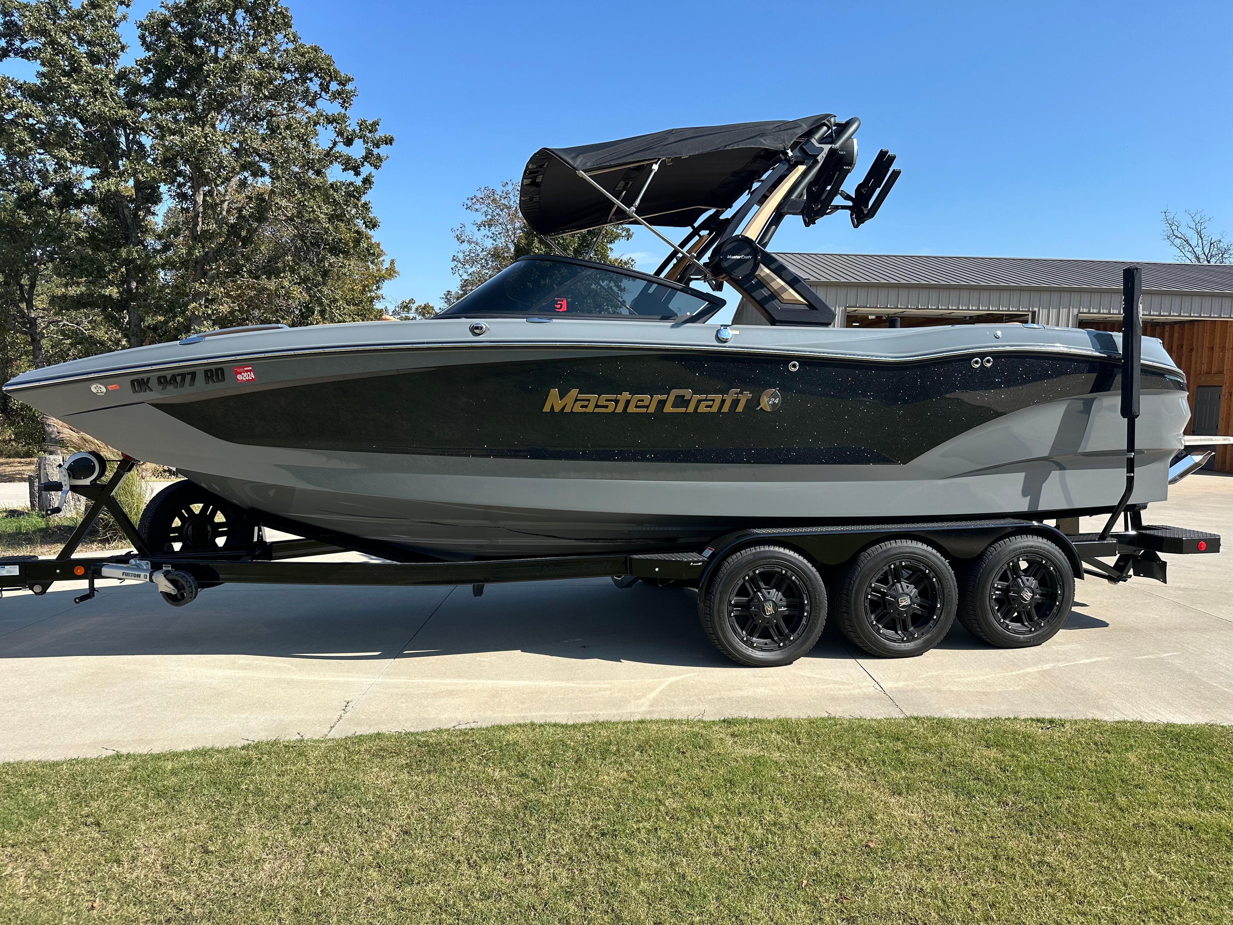 MasterCraft X24 2022 MasterCraft X24 boat on trailer, parked outdoors on a sunny day.