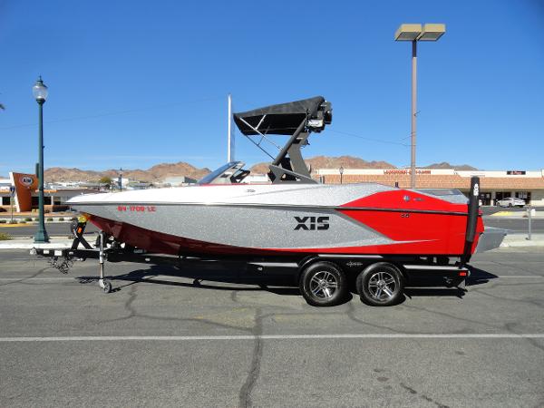 Axis A22 2016 Axis A22 boat on trailer, red and gray, parked in urban setting.