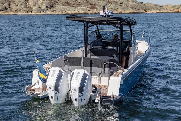 Nimbus T9 Nimbus T9 #121 Twin Engine 2023 boat cruising on water with rocky shoreline in background.