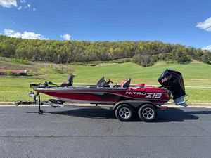 Nitro Z19 2025 Nitro Z19 boat on trailer, parked on road with scenic green hills in background.