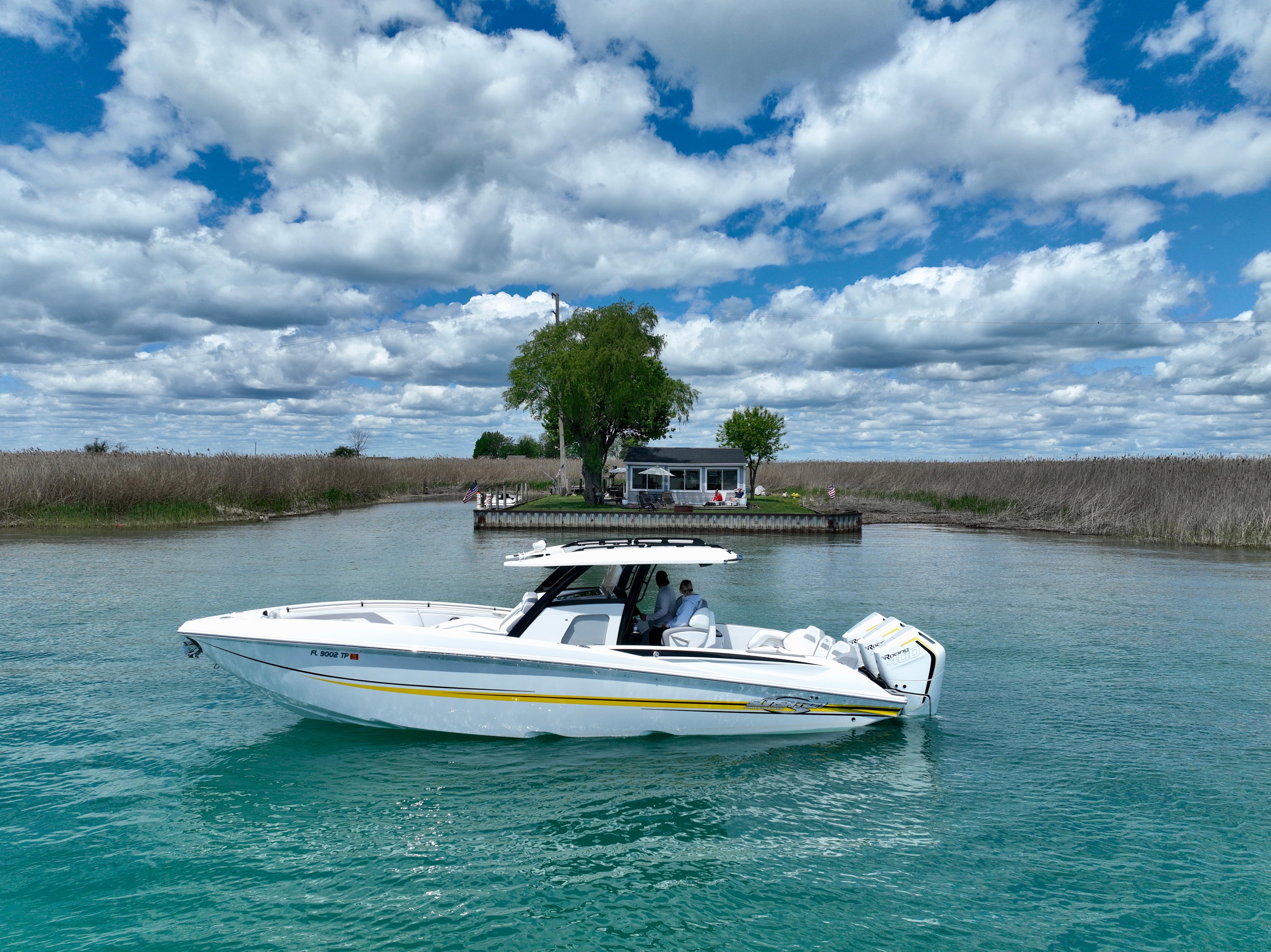 Sunsation 34 CCX 2024 Sunsation 34 CCX boat cruising on clear water under a partly cloudy sky.