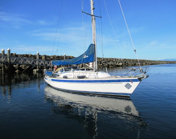 Hallberg-Rassy 34 2003 Hallberg-Rassy 34 sailboat docked in calm waters under clear blue sky.