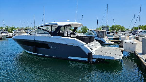Cruisers Yachts 390 Express Coupe 2017 Cruisers Yachts 390 Express Coupe docked in a marina under clear blue skies.