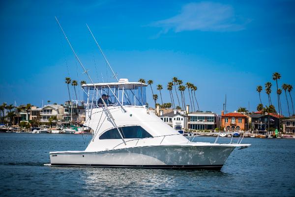 Luhrs 34 Convertible 2001 Luhrs 34 Convertible boat cruising near coastal homes and palm trees.